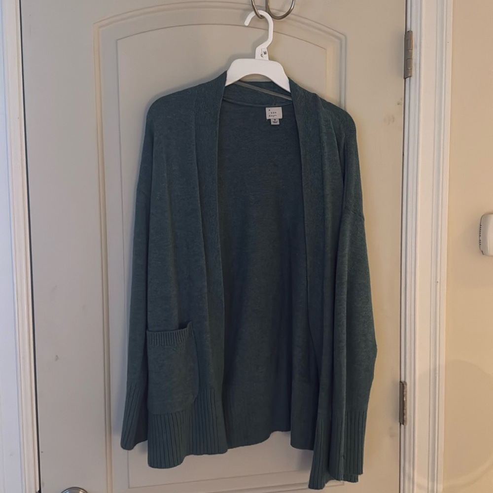 Geeen sweater. Open in front. Pocket in front